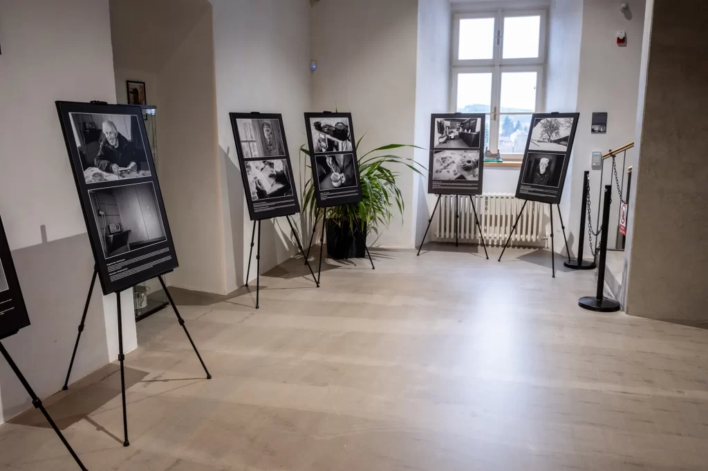Vnitřní umělecká expozice, která je součástí putovní výstavy, zobrazuje černobílé fotografie na stojanech uspořádaných v místnosti s velkým oknem a hrnkovou rostlinou, evokující esenci „Už není toho dechu.